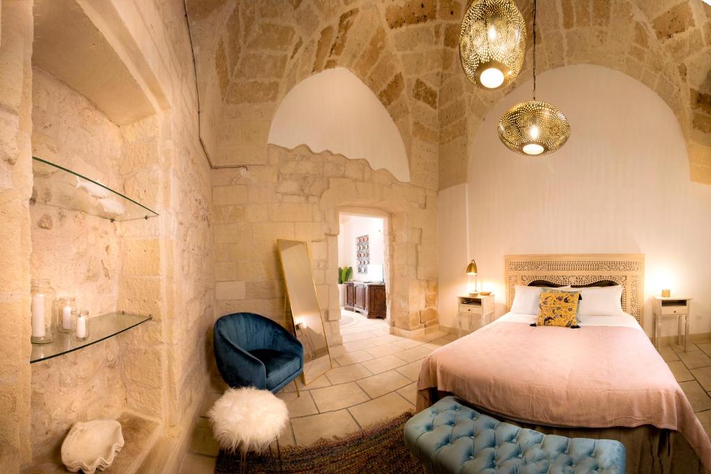 - une chambre avec un lit et une chaise bleue dans l'établissement FORLEO Historic Apartments, à Lecce
