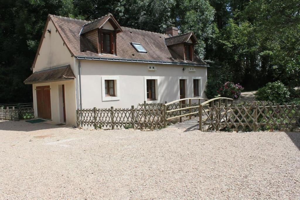 une petite maison blanche avec une clôture en bois dans l'établissement Gîte 8 personnes cadre authentique proche château du loir, à Luceau