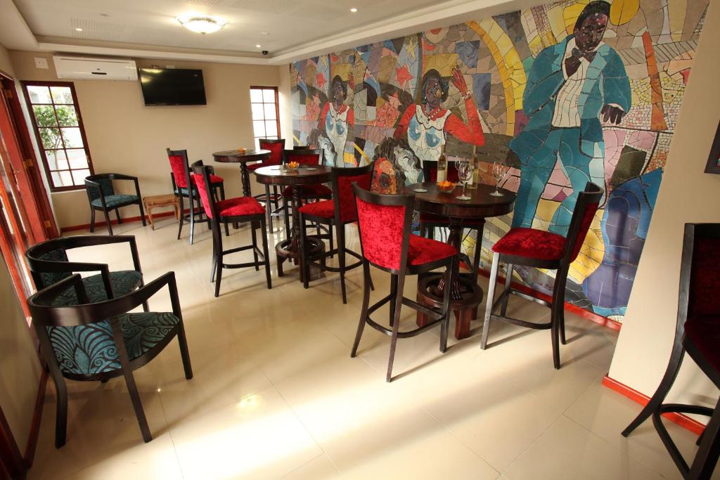 a restaurant with tables and chairs and a mural at Park Place Boutique Guesthouse in East London