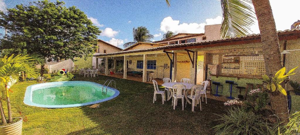 a house with a swimming pool and a table and chairs at Qavi - Casa com piscina na Praia de Cotovelo in Parnamirim