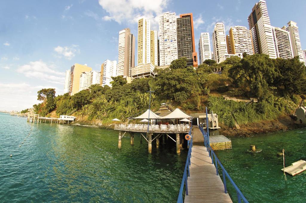 a pier with a restaurant on the water in a city at Sol Victoria Marina in Salvador
