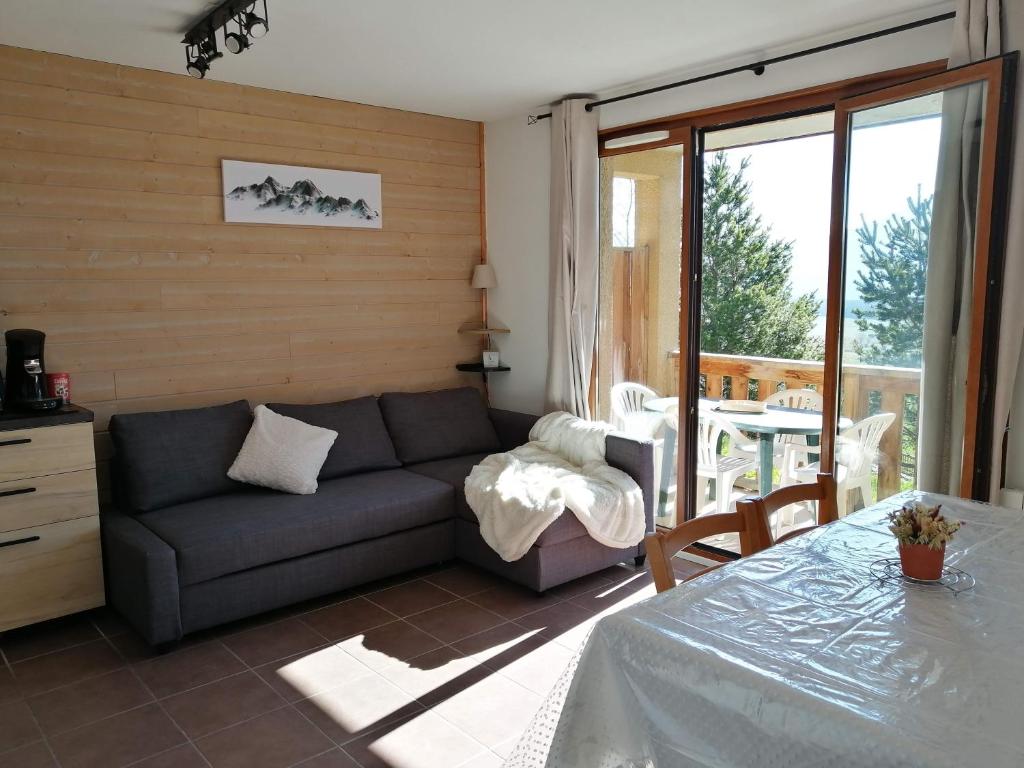a living room with a couch and a table at Appartement 2 Chambres au calme in Les Angles