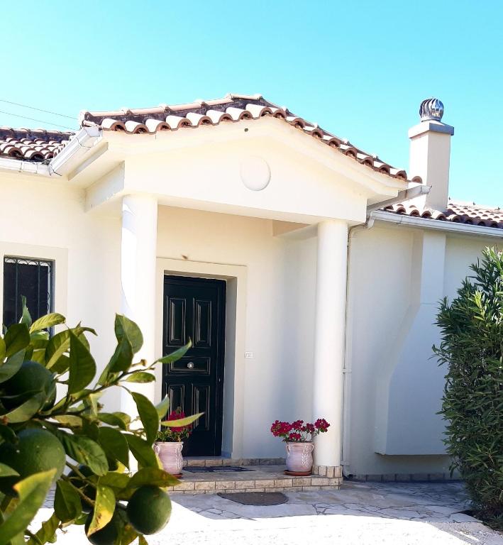 a white house with a black door at Hannas Paradise - Villa Evi in Skafidia