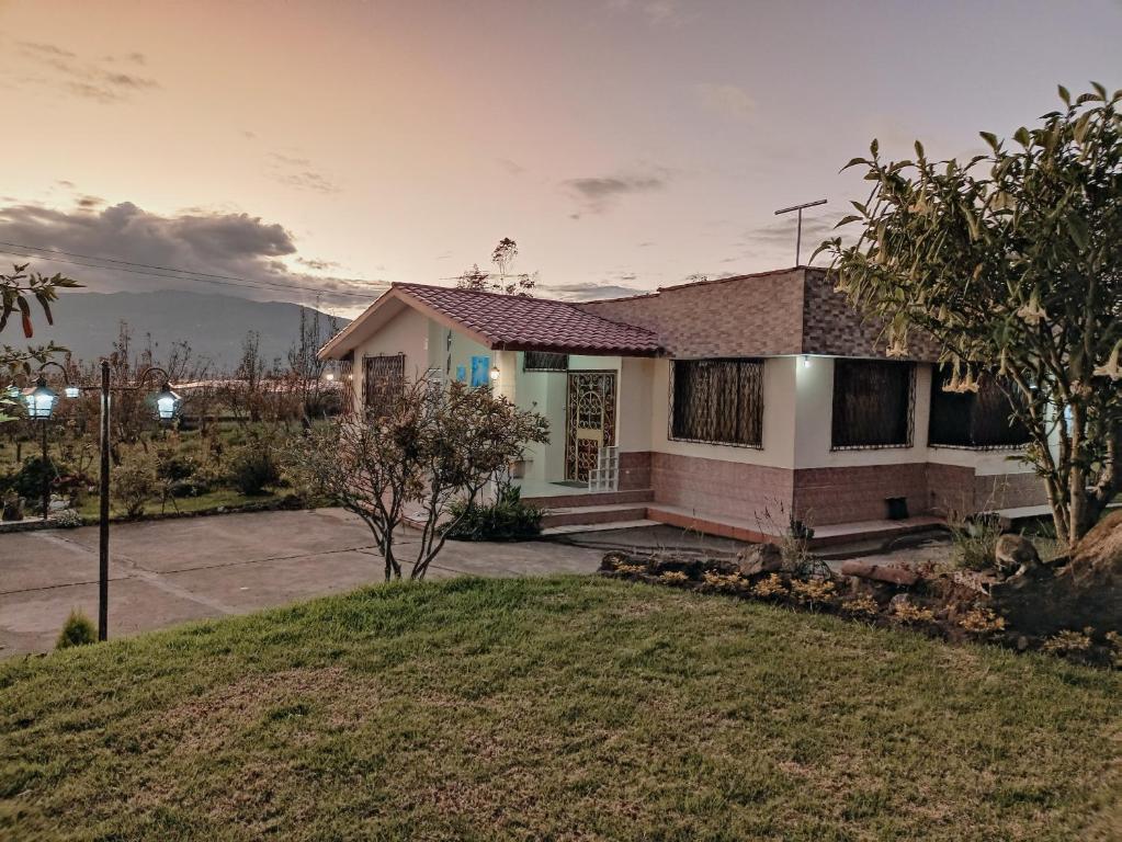 une maison avec une pelouse devant elle dans l'établissement Casa de campo Pillaro - Activa, à Píllaro