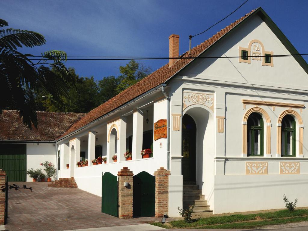 un edificio blanco con techo rojo en Flórián Vendégház, en Villánykövesd