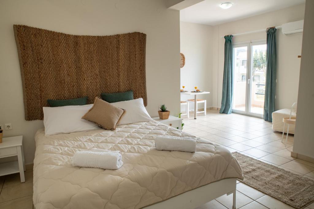 um quarto com uma cama grande com duas almofadas em Maresia Apts & Studios em Arillas