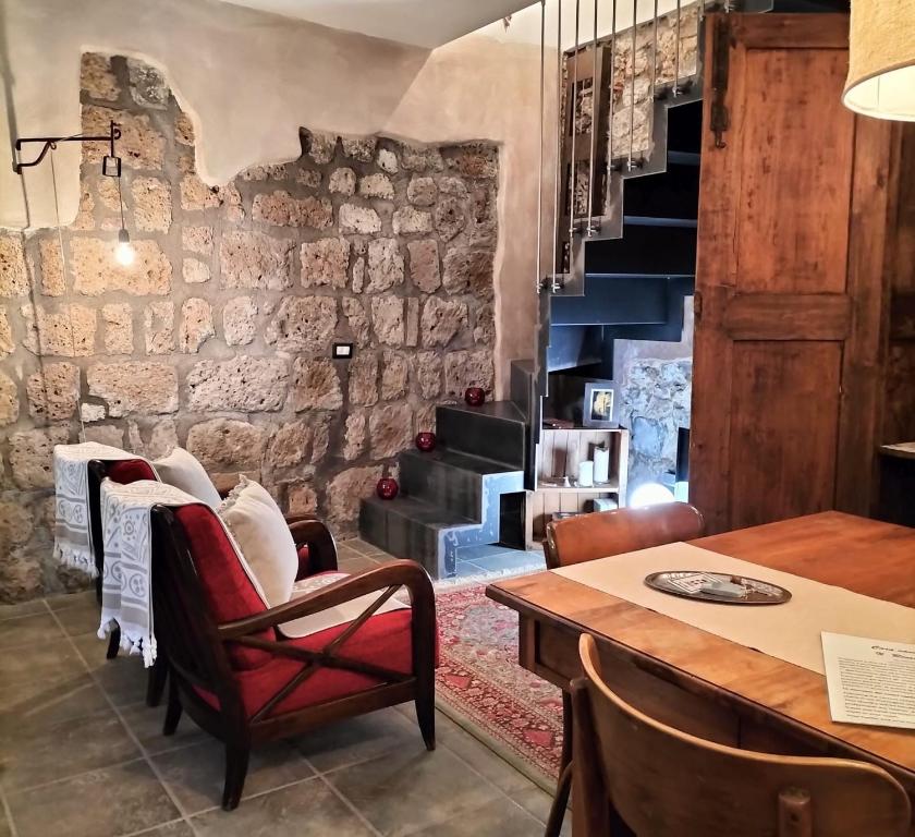 トゥスカーニアにあるIl Riuscelloの石壁の客室で、テーブルと椅子が備わります。