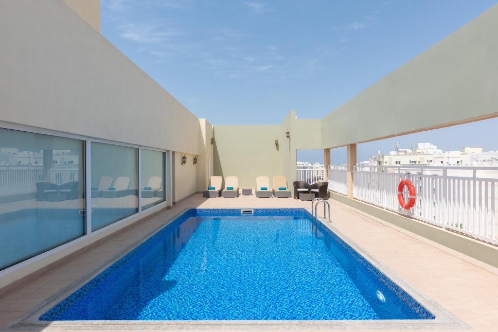 einem Pool im Obergeschoss eines Gebäudes in der Unterkunft Centara Life Muscat Dunes Hotel in Muscat