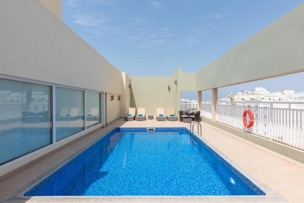 a swimming pool on the upper floor of a building at Centara Life Muscat Dunes Hotel in Muscat