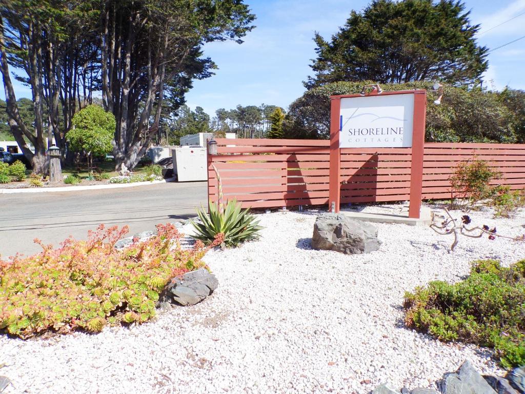 a sign in front of a wooden fence at Shoreline Cottages in Fort Bragg