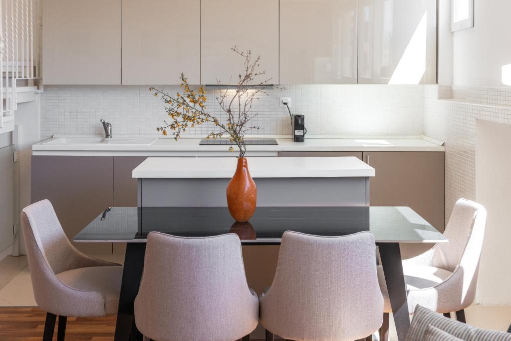 une cuisine avec une table, des chaises et un vase. dans l'établissement Villa Homa, à Dubrovnik