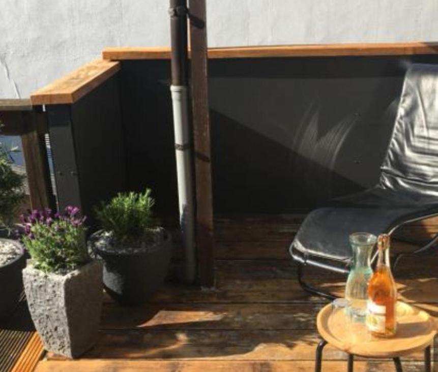 Ferienwohnung City Loft في كيل: فناء فيه كرسي وطاولة وبعض النباتات