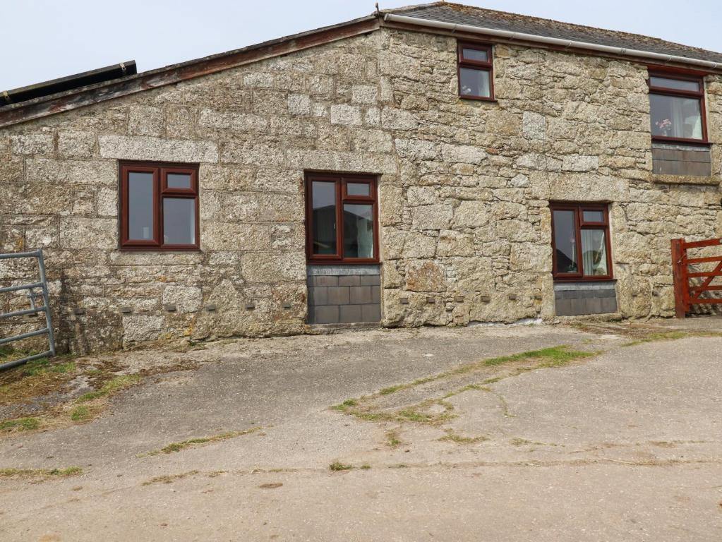 a stone building with windows on the side of it at Foxes in Lanivet