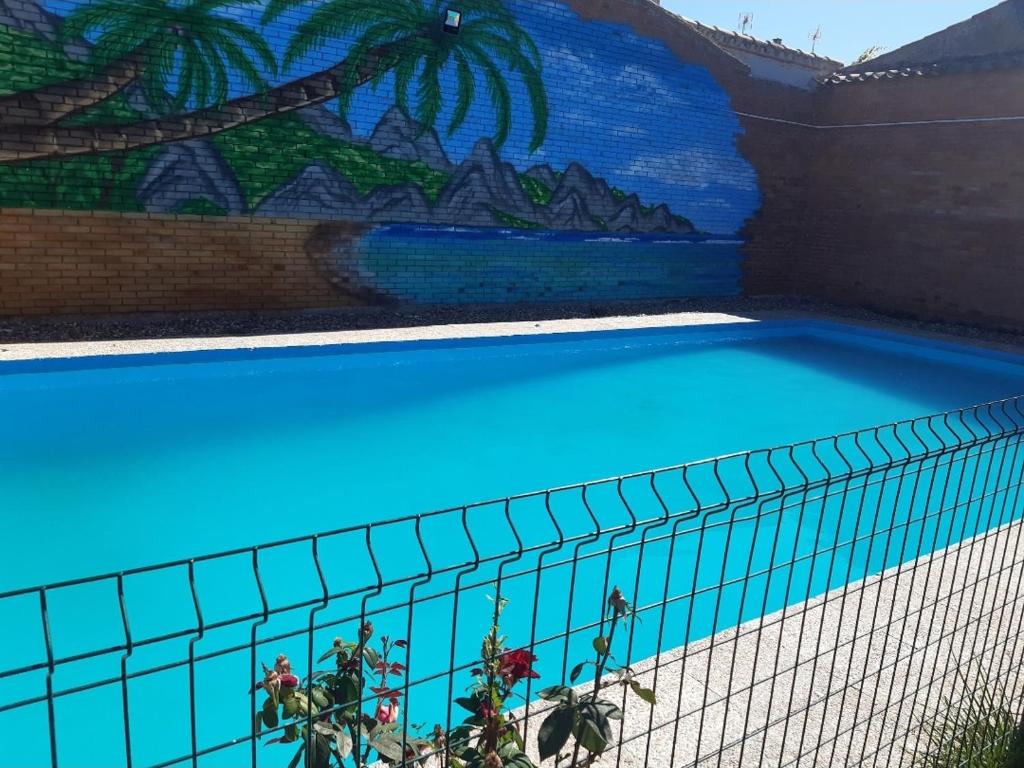 une piscine bleue avec une fresque murale dans l'établissement Casa de pueblo, à Babilafuente