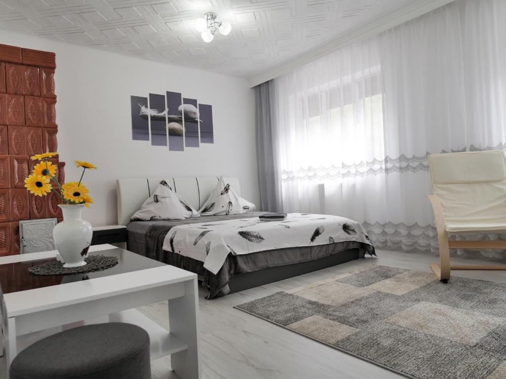 a bedroom with a bed and a table and a chair at Casa Fery in Băile Herculane