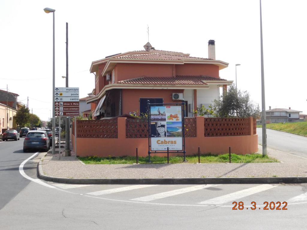 un pequeño edificio con un cartel delante en B&B DiVino, en Cabras