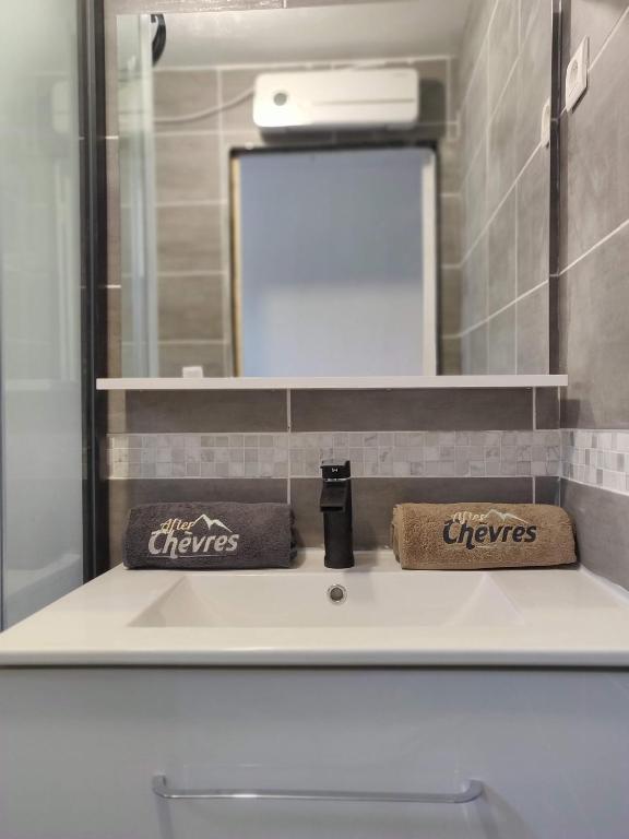 - un lavabo avec 2 serviettes et un miroir dans l'établissement After-Chèvres, à Villefort
