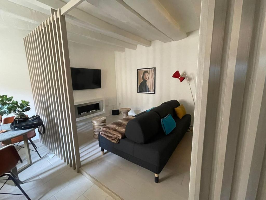 ミラノにあるBrera Charme Suiteのリビングルーム(黒いソファ、テレビ付)