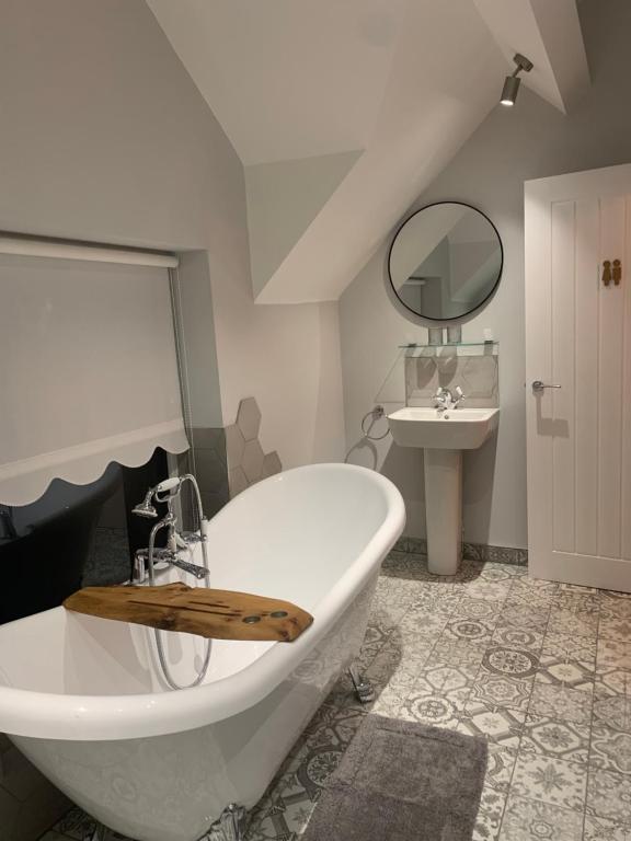 Conisbrough的住宿－Minneymoor lodge，浴室配有大型白色浴缸和水槽
