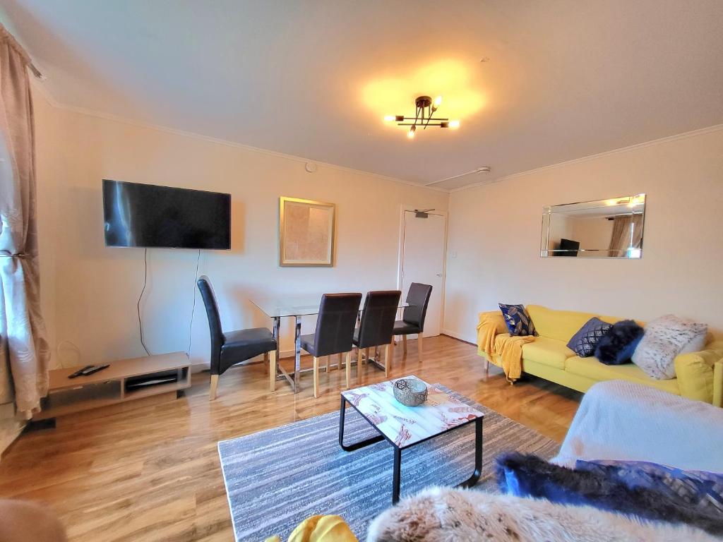 a living room with a yellow couch and a table at 3 Bedroom Aprtmt at Sensational Stay Serviced Accommodation Aberdeen- Froghall Avenue in Aberdeen
