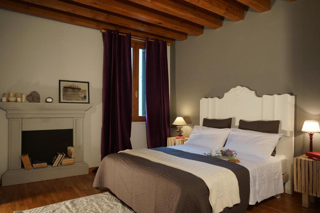 a bedroom with a large bed and a fireplace at Avogari B&B in Treviso