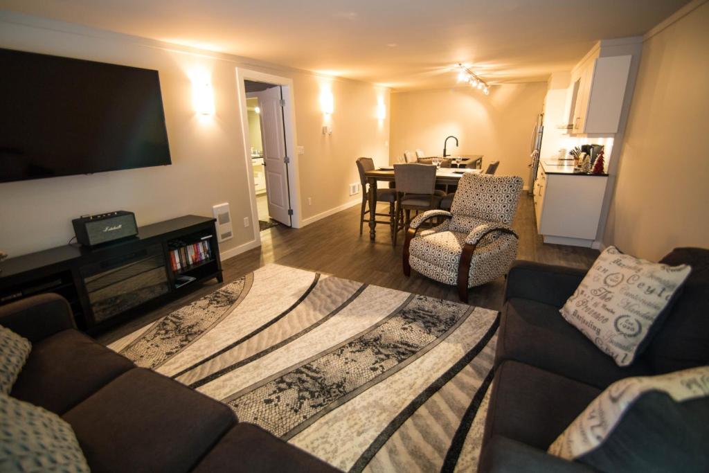 a living room with a couch and a flat screen tv at Clipperton Suite by Revelstoke Vacations in Revelstoke