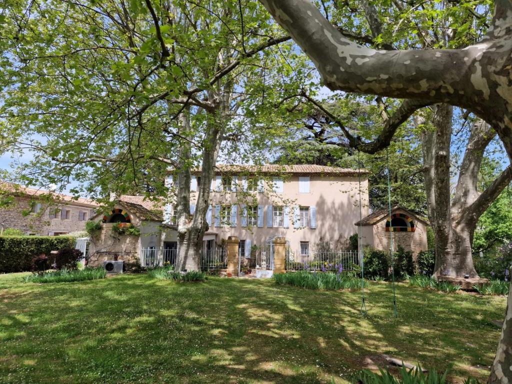 une grande maison avec des arbres dans la cour dans l'établissement 1560- Domaine Des Cinq Jardins- A Magical and Authentic Mansion, à Fuveau