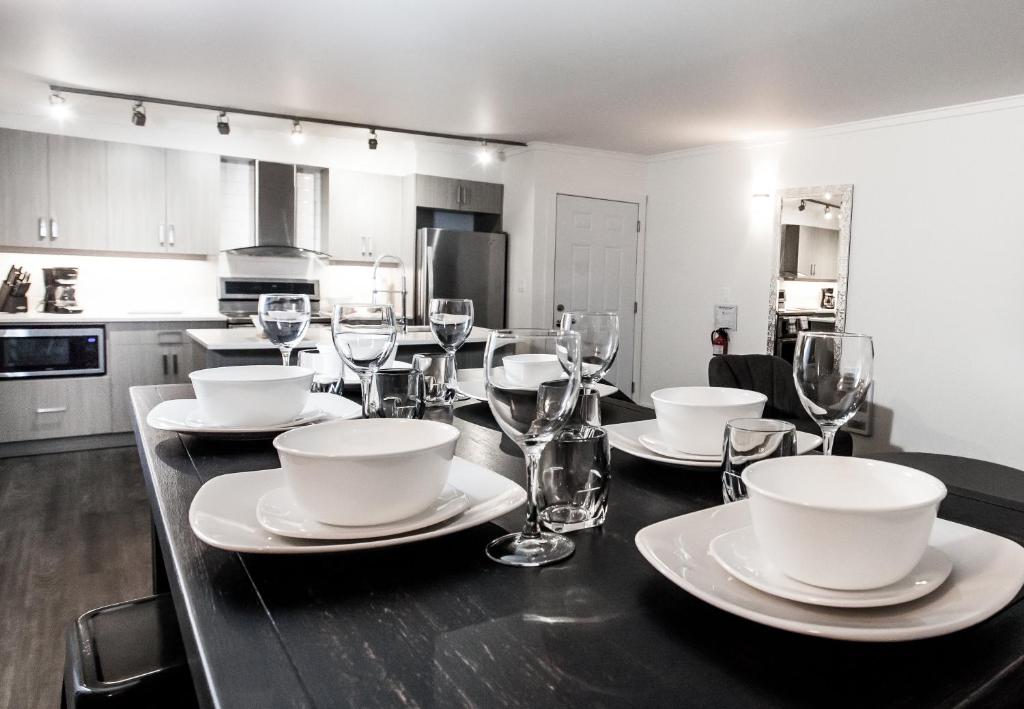 a dining room table with plates and wine glasses at Novlan Suite by Revelstoke Vacations in Revelstoke