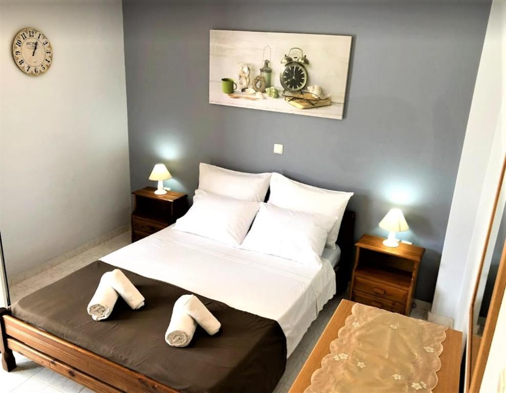 sypialnia z łóżkiem i kapciami na podłodze w obiekcie Menelaos Apartments w Adelianos Kampos