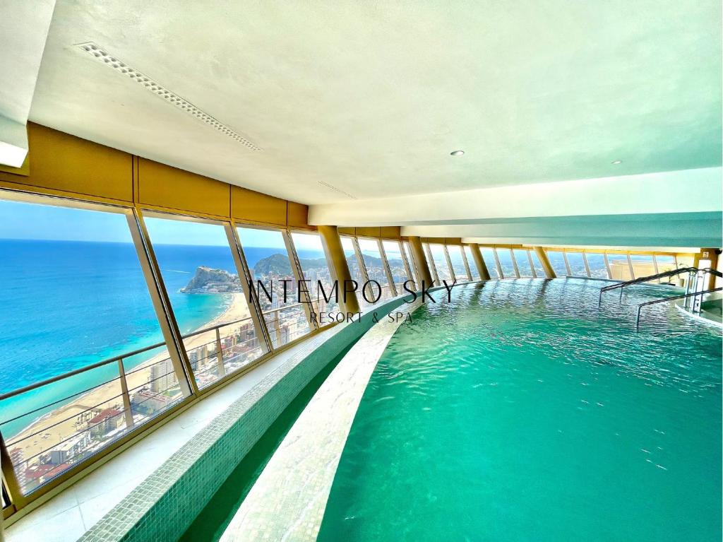 una piscina con el océano en el fondo en INTEMPO SKY Resort & Spa, en Benidorm