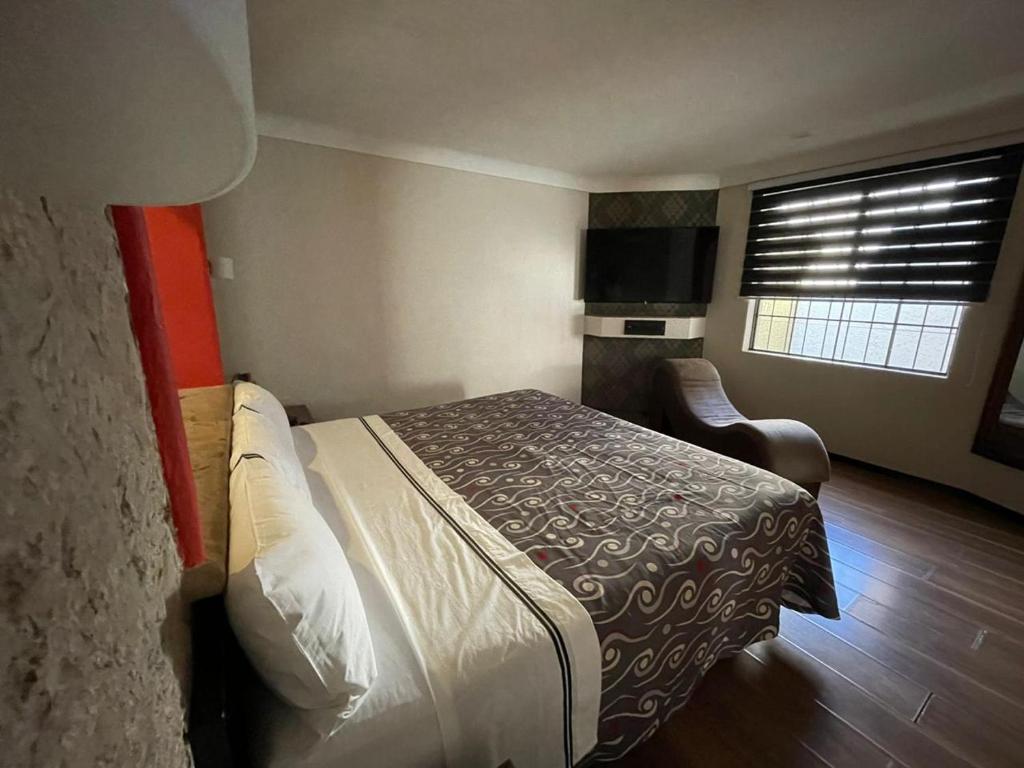 a hotel room with a bed and a window at Motel Astoria in Aguascalientes