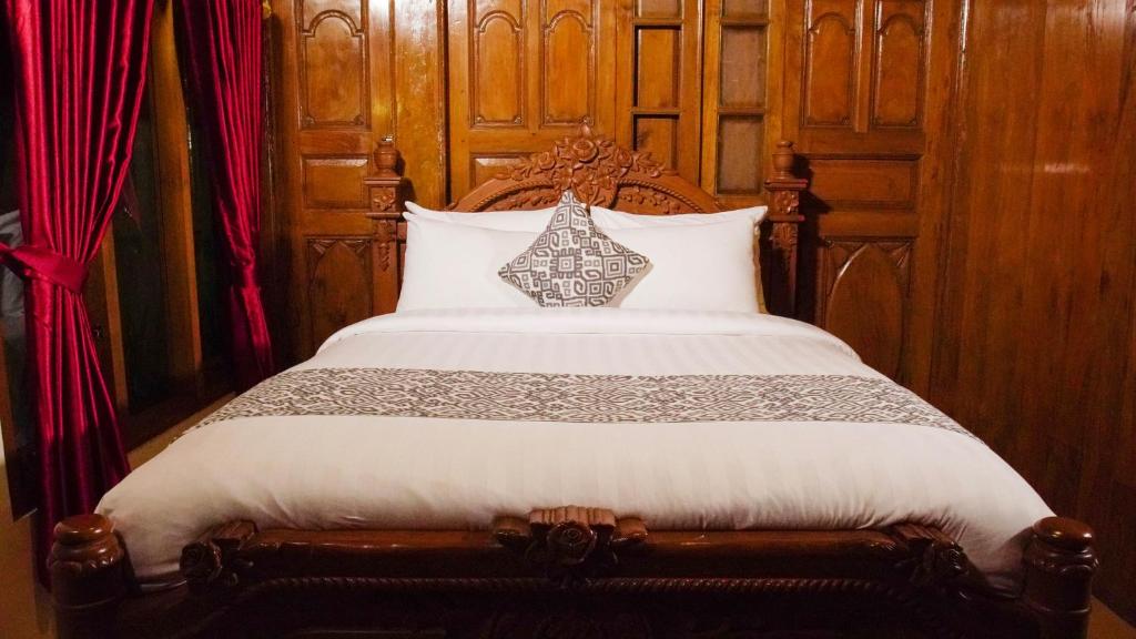Postel nebo postele na pokoji v ubytování Kampoeng Joglo Boutique Hotel