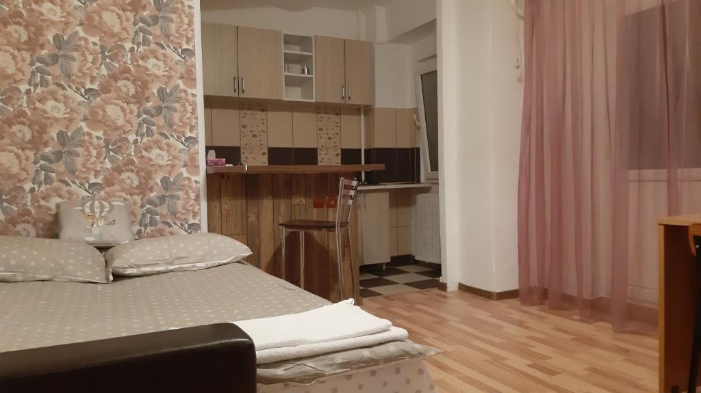 Una pequeña habitación con una cama y una cocina. en Studio Timpuri Noi 50, en Bucarest
