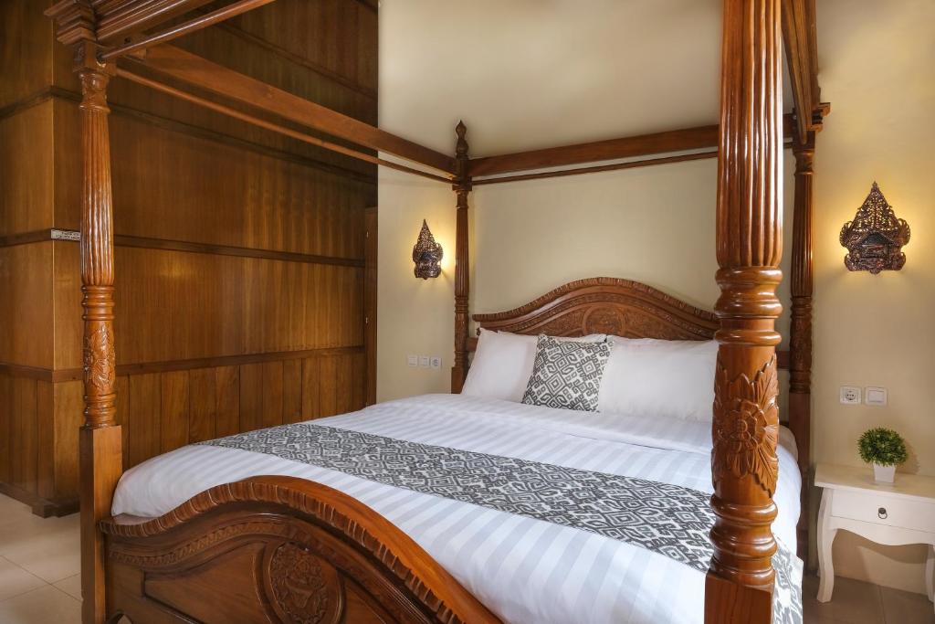 Postel nebo postele na pokoji v ubytování Kampoeng Joglo Boutique Hotel