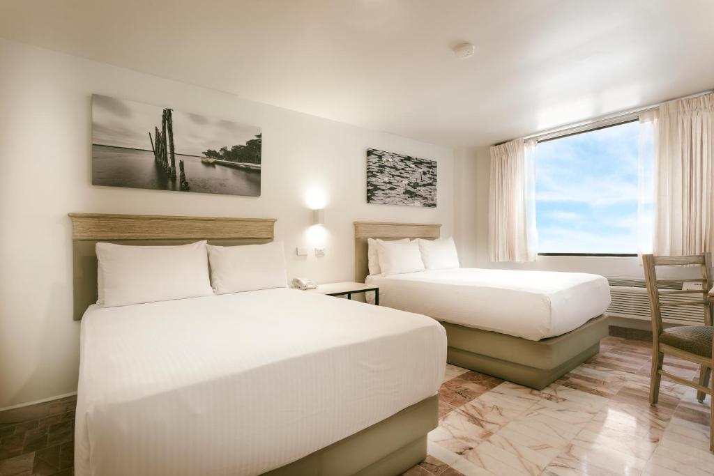 比亞埃爾莫薩的住宿－Gamma Villahermosa Centro，酒店客房设有两张床和窗户。