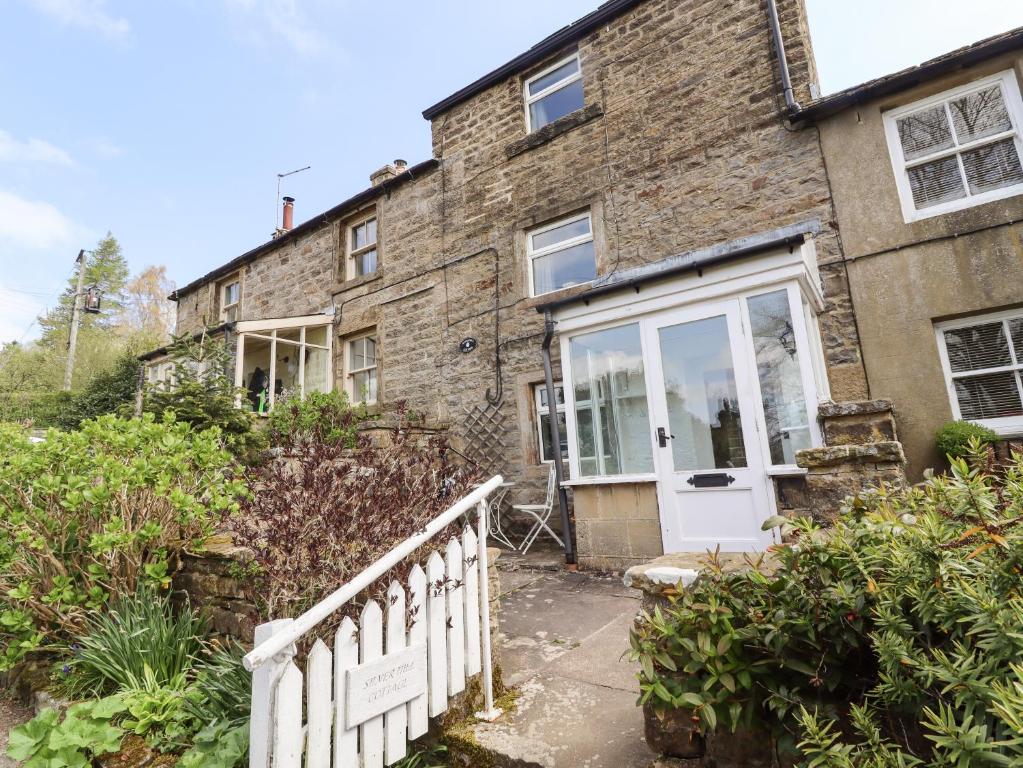 an exterior view of a brick house with a white door at Silver Hill Cottage in Harrogate