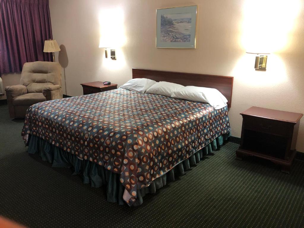 une chambre d'hôtel avec un lit et une chaise dans l'établissement Marysville Surf Motel, à Marysville