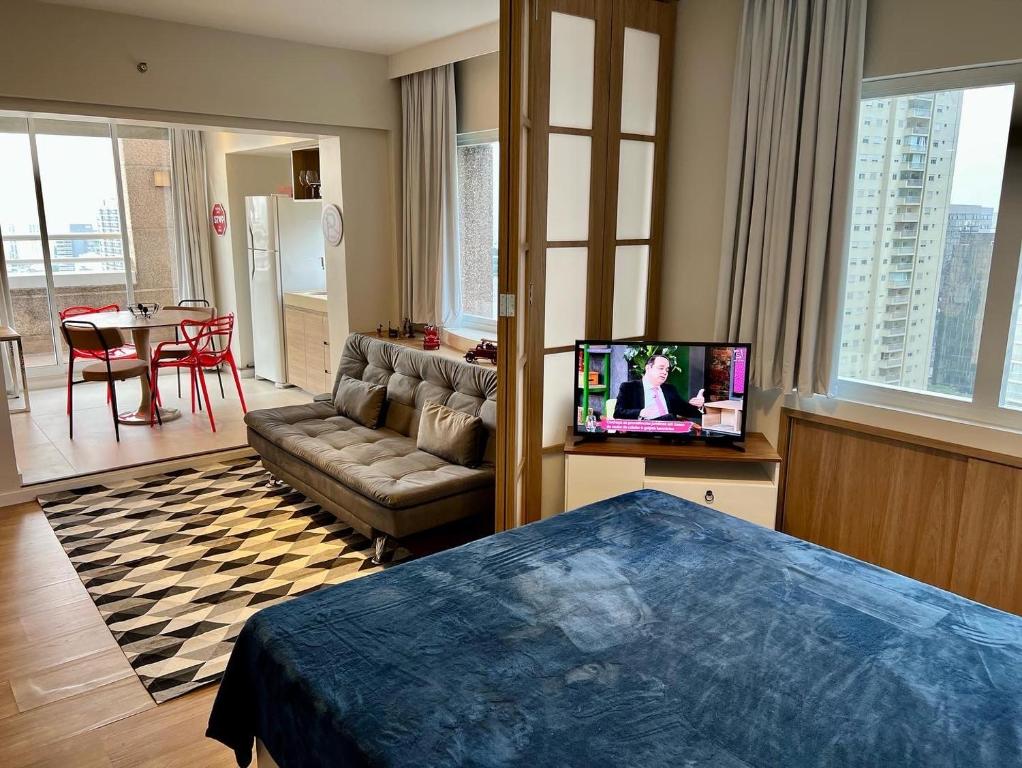 une chambre d'hôtel avec un lit, un canapé et une télévision dans l'établissement Beneficência Portuguesa, 50 metros, à São Paulo