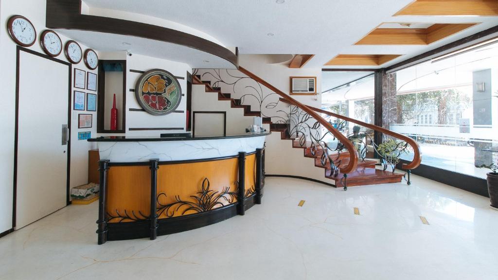 a staircase in a house with a clock on the wall at RedDoorz Premium @ Nick Hotel Gerona Tarlac in Tarlac