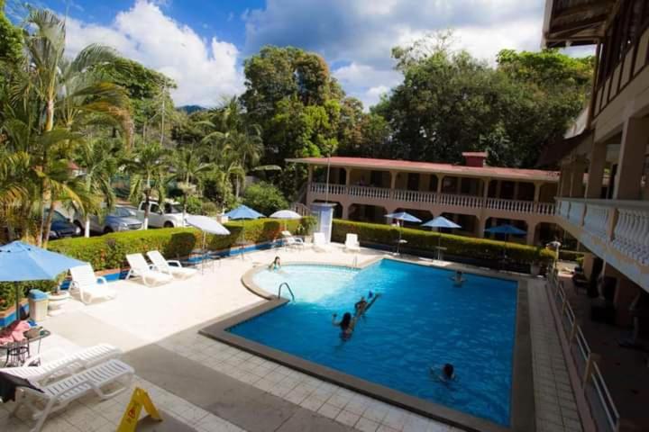 a large swimming pool with a person in the water at House of the Macaws in Tarcoles