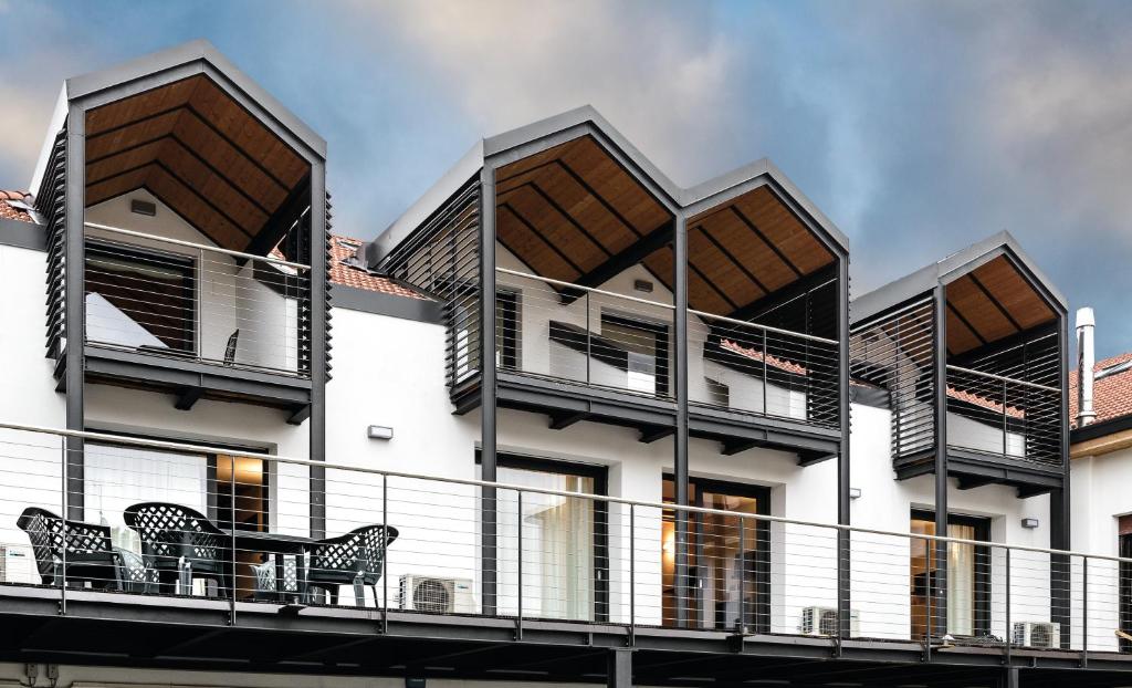 a building with two chairs on a balcony at Faber Apartments-Residence Style in Arona