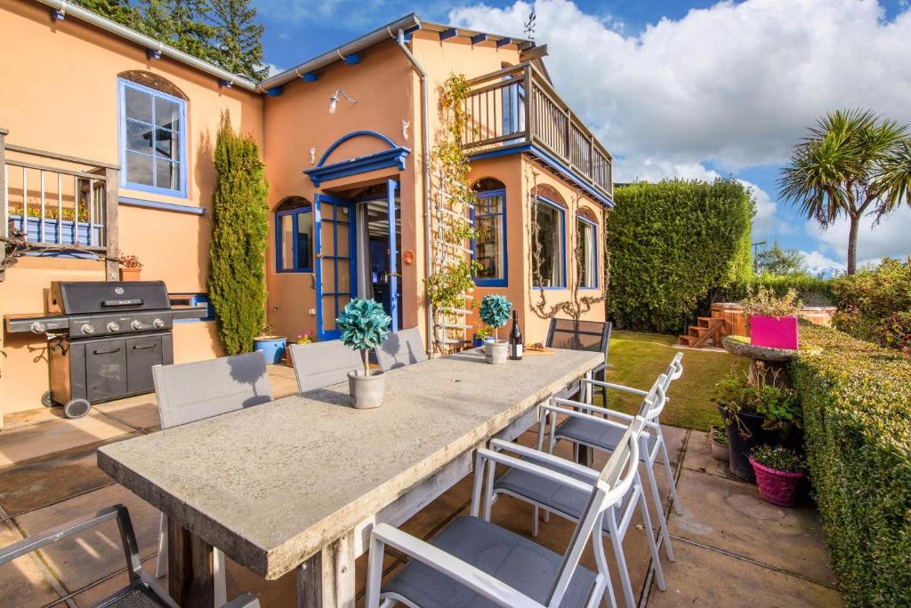 a table and chairs in front of a house at Sunny Lakeview Villa in Queenstown