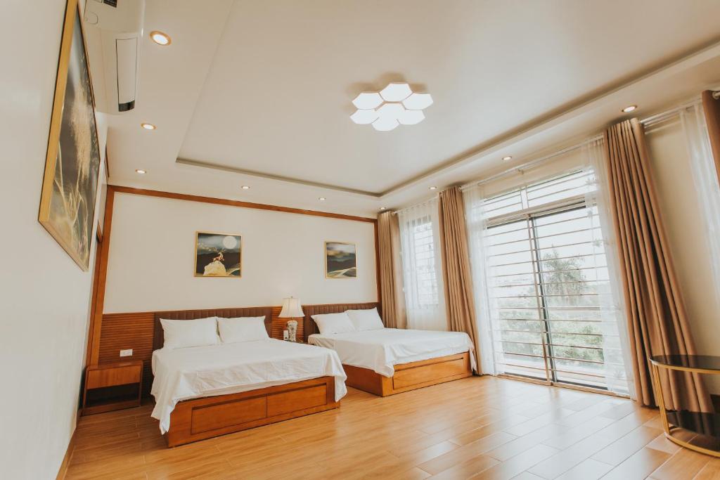 sypialnia z 2 łóżkami i oknem w obiekcie Bảo Châu Hạ Long Hotel w Ha Long