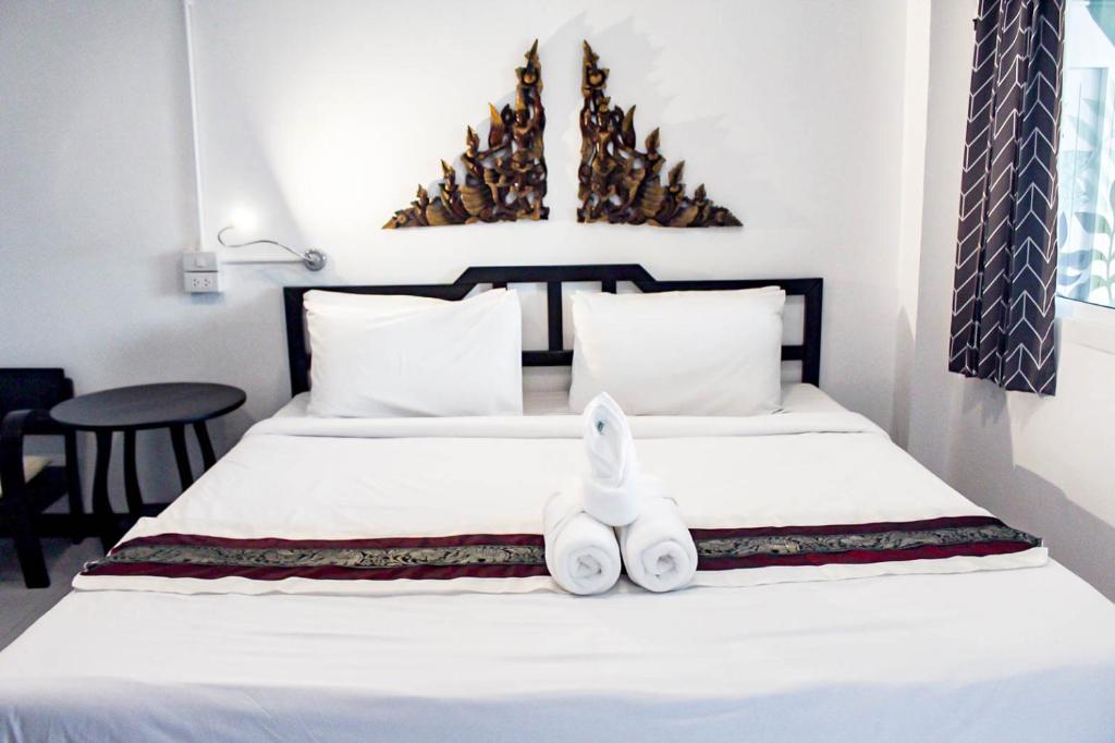 ein Schlafzimmer mit einem Bett mit zwei weißen Handtüchern darauf in der Unterkunft Vlodge House in Chiang Mai
