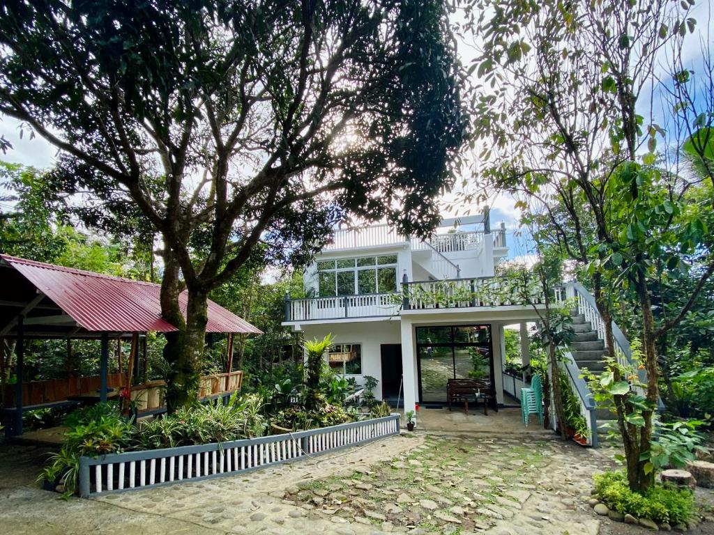 een wit huis met een balkon en bomen bij Casa Calanog in Tagaytay
