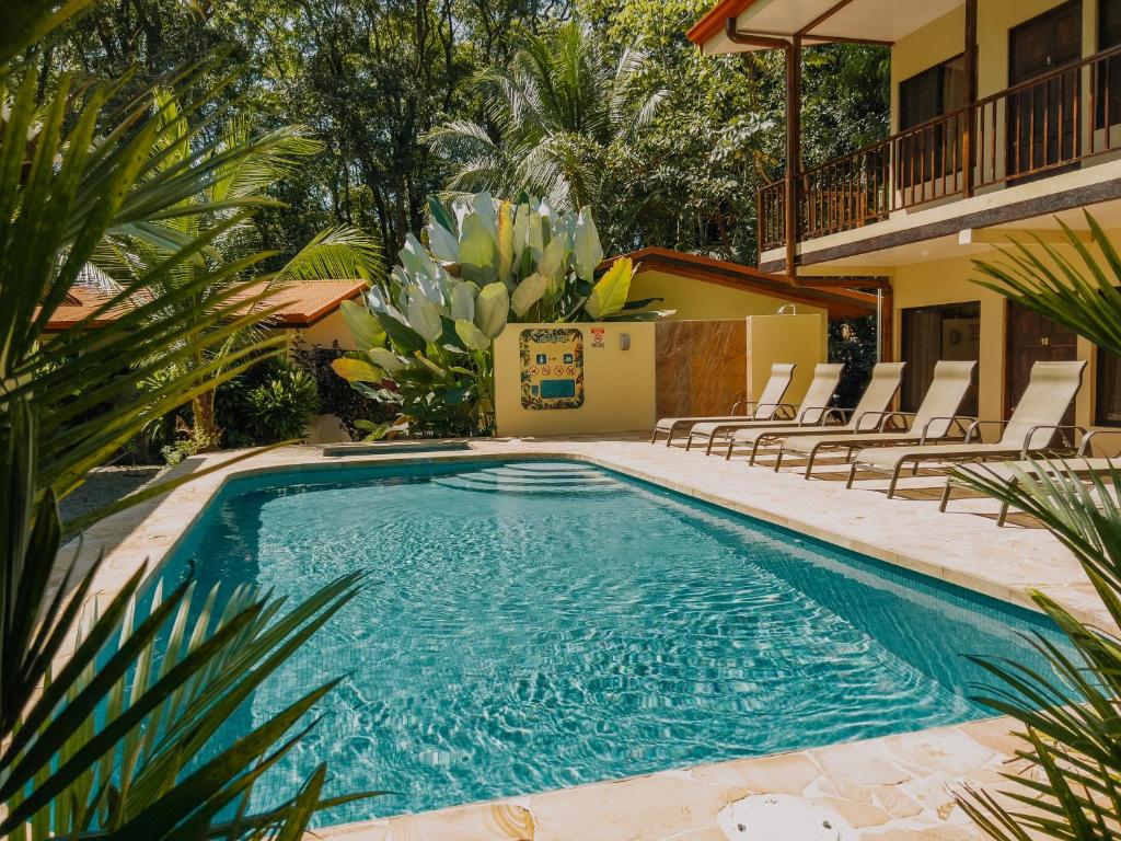 een zwembad met stoelen en een huis bij Tropical Beach in Uvita