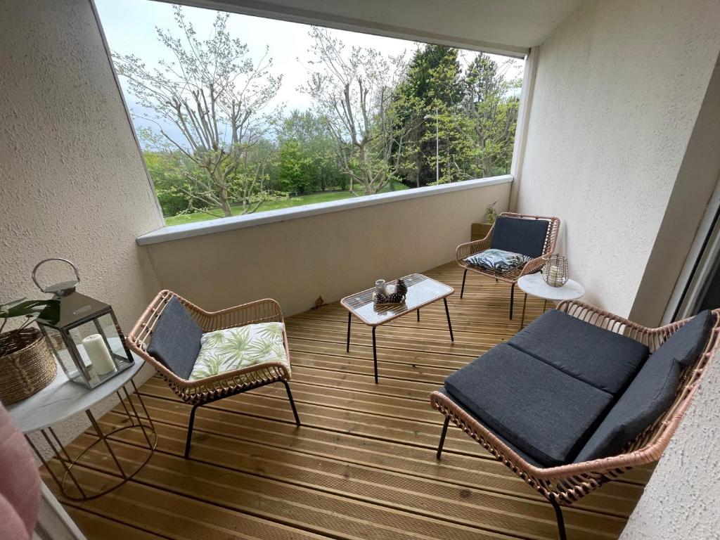 a balcony with chairs and a table and a window at Splendide appartement 40m2 familial cabourg in Cabourg