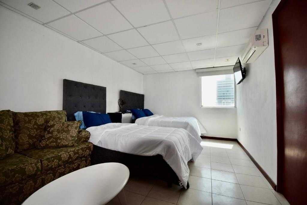 a hotel room with two beds and a couch at Room in Guest room - Habitacion Tipo Hotel En Obispado in Monterrey