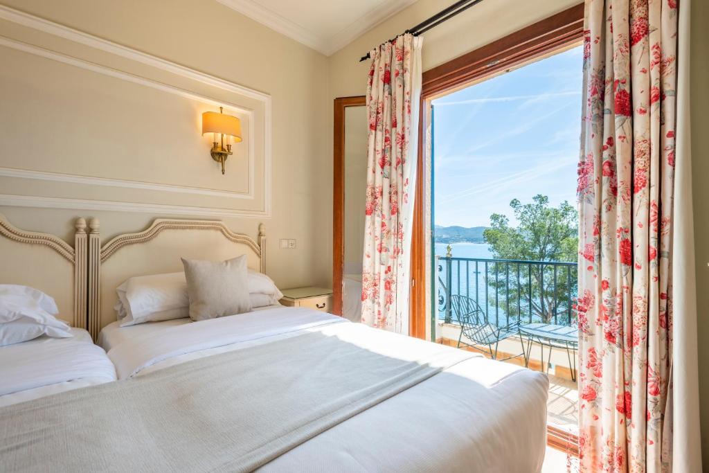 a bedroom with a bed and a large window at Hotel Cala Fornells in Paguera