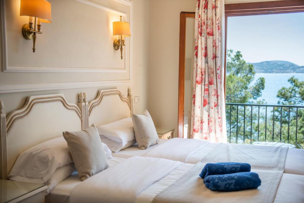 a bedroom with a bed with a large window at Hotel Cala Fornells in Paguera